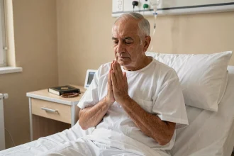 Homme âgé en lit d'hôpital effectuant le tayammum avec les paumes jointes en signe de recueillement